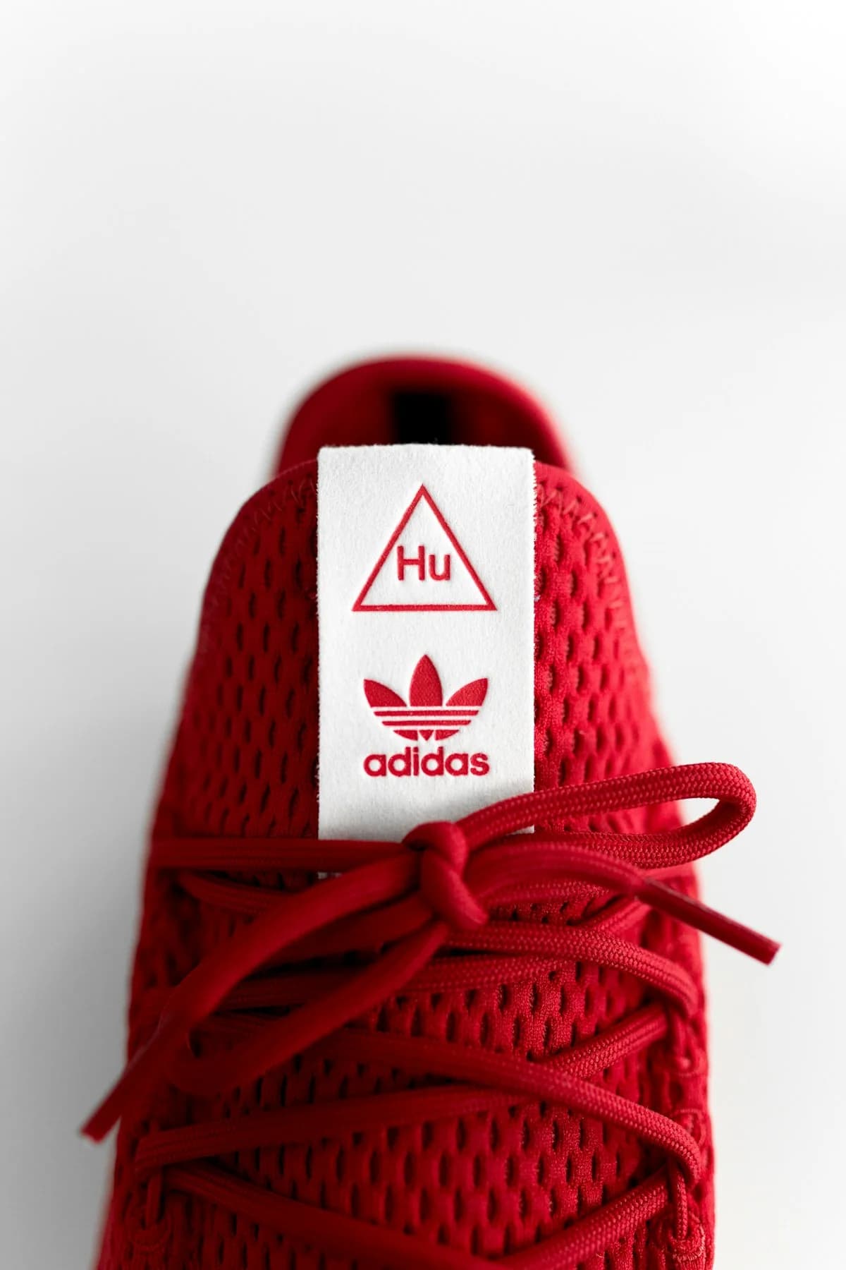 A close-up of a red sneaker photographed against a light background.