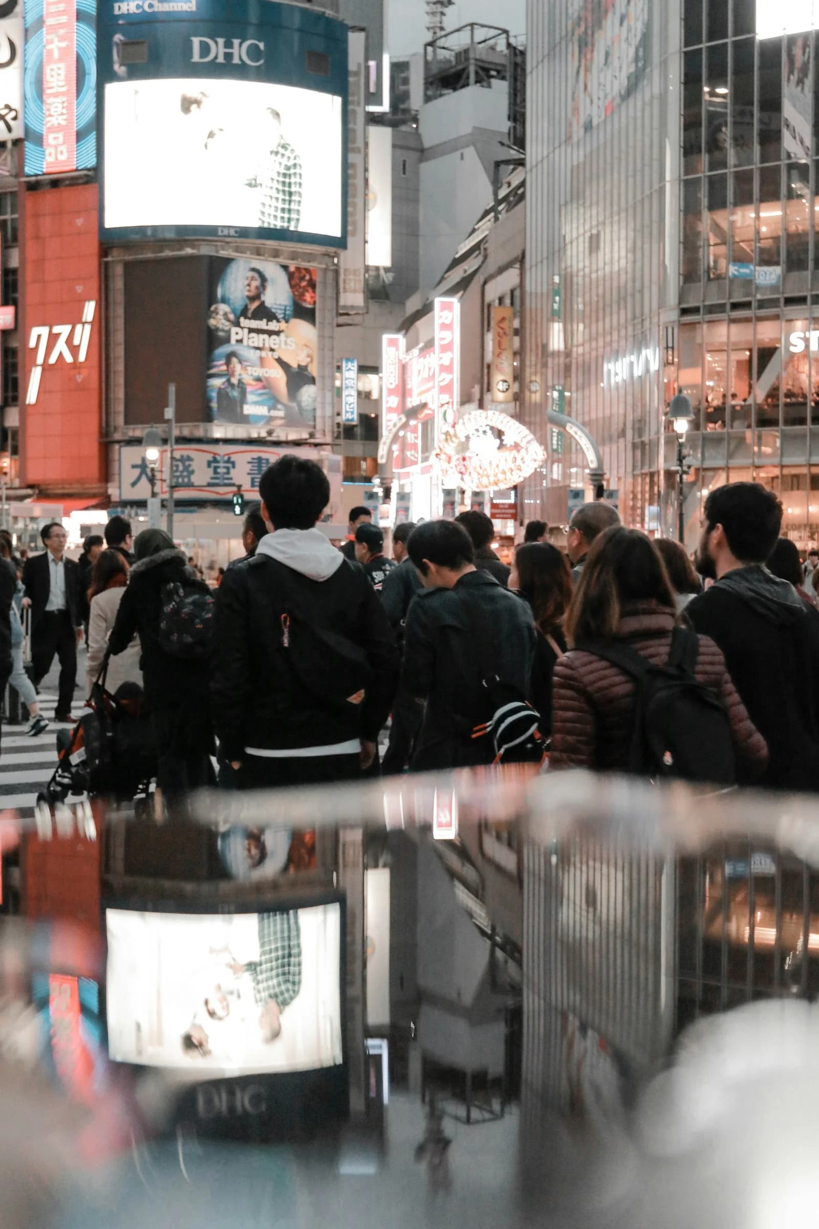 A lively Tokyo street with pedestrians and illuminated signs.
